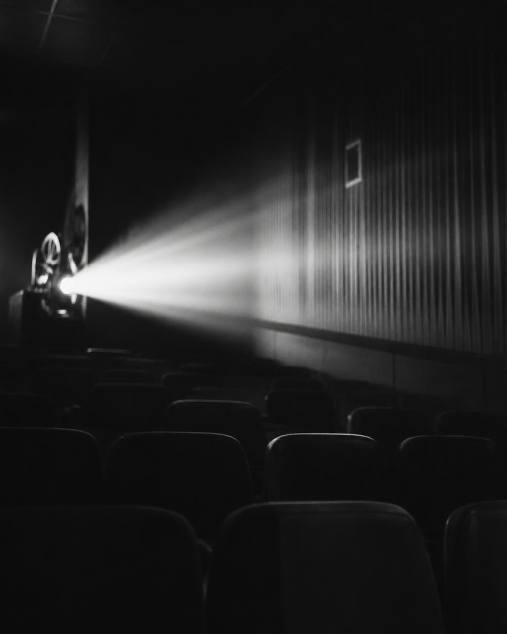 A projector beam crossing a darkened screening room